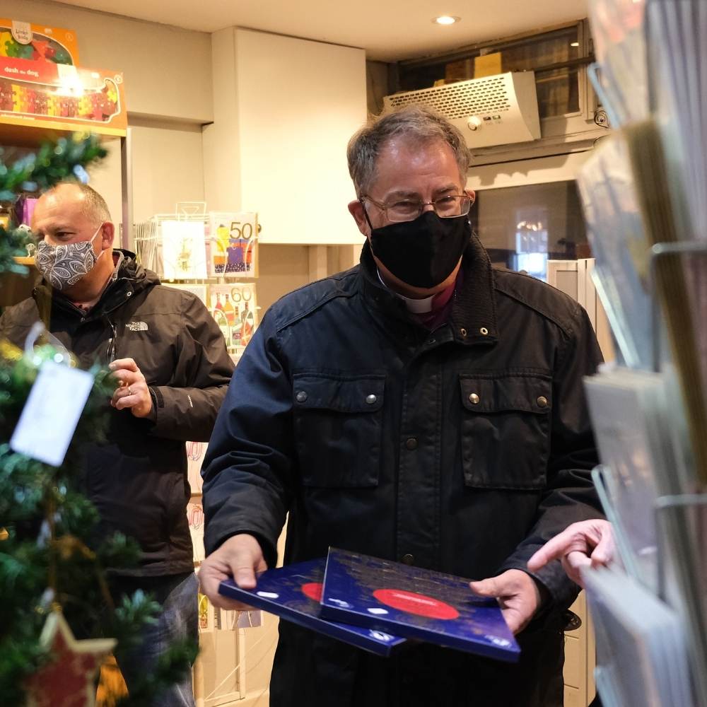 The Bishop of Oxford holding two advent calendars in Wendover community shop